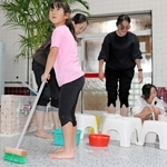 浴場の床や椅子を清掃する親子連れ＝神戸市長田区の本庄湯