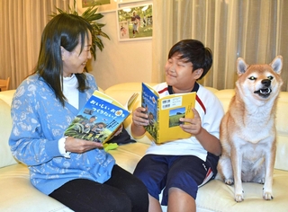 「頑張ったご褒美やね」。本の完成を喜ぶ新宅佑輔さん（右）と母の雅美さん＝神戸市西区