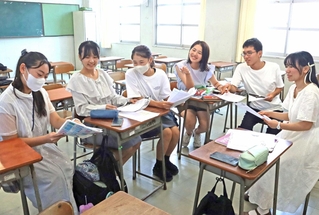 細かい表現にこだわり、意見を交わしながら英訳に取り組む文芸部の生徒＝長田高校