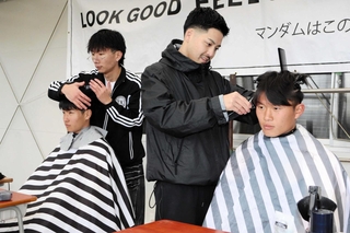 思い思いに要望を伝えてカットしてもらうサッカー部員＝神戸弘陵学園高校