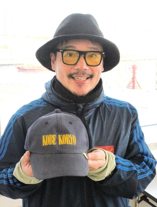 現役時代に練習で使っていたキャップを手に後輩へエールを送る松井和也さん＝神戸新聞社