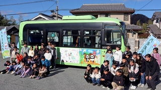 装飾されたバスと記念撮影する小学生たち＝神戸市北区淡河町淡河