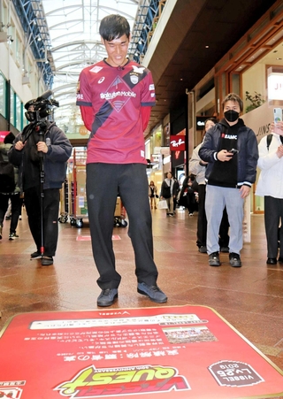 床面のパネルに見入る山川哲史主将＝神戸・三宮センター街