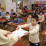 担任教諭から児童１人１人に通知表が手渡された＝長田南小学校
