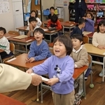 担任の先生から一人ずつ通知表を受け取る子どもたち＝長田南小学校