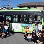 装飾されたバスと記念撮影する小学生たち＝神戸市北区淡河町淡河