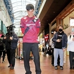 床面のパネルに見入る山川哲史主将＝神戸・三宮センター街