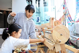 被災地で紡がれてきた「さをり織り」に挑戦する姉妹＝１７日午前１１時１４分、ＢＢプラザ