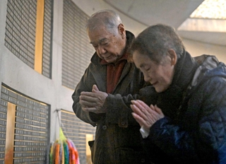 母の名が刻まれた銘板に手を合わせる三木健次さん（左）と妻の貞子さん＝１７日午前７時１分、東遊園地（撮影・大田将之）