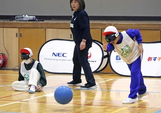 目隠しをしてボールを投げる子どもたち＝八多学園