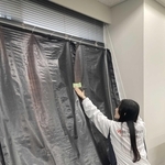 「１．１７のつどい」の前日、ビルの窓に幕を張る社員（関西電力送配電神戸本部提供）