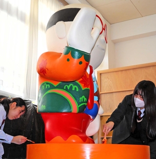 熊八像に色を塗る矢野美晴さん（左）と濵口陽依さん。神戸の魅力を詰め込んだデザインを考えた＝神戸北高校