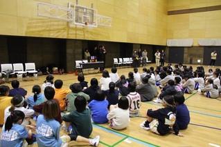 大学生の話を真剣に聞く小学生＝神戸市立磯上体育館（提供）