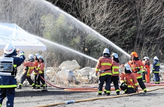火災が住宅地に燃え広がらないよう、民家に見立てたテントに向けて放水する市消防局員ら＝北区淡河町野瀬