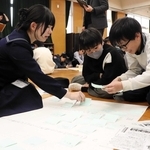 高校生の助言を受けながら、自分の考えをまとめた付箋を貼る小学生＝横尾小学校