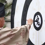 的の中心に「鬼」の文字を書く宮司＝神戸市北区淡河町勝雄、淡河八幡神社