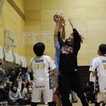 必死に手を伸ばしてボールを取り合う小学生と大学生＝神戸市立磯上体育館（提供）