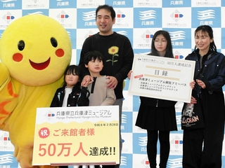 ５０万人目の来館者となった細木秀雄さん（中央）と家族＝県立兵庫津ミュージアム