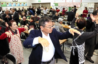 ごった返す神戸沖洲会館で、沖永良部島の民謡「サイサイ節」に合わせて踊る出身者ら＝神戸市中央区宮本通２