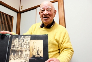 アルバムを手に父寿生さんとの思い出を振り返る重村仁さん。２人が１枚に納まる写真はそう多くない＝灘区福住通