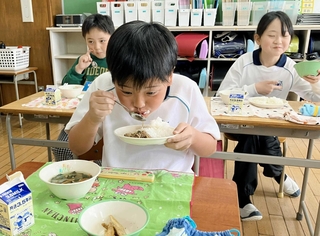 神戸ビーフを使った牛丼を頬張る児童＝丸山ひばり小学校