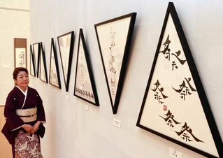 自由な筆遣いの自作を見つめる高砂京子さん＝中央区脇浜海岸通１