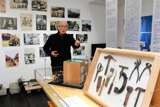 在日コリアンに関する展示を説明する金信鏞さん＝神戸在日コリアンくらしとことばのミュージアム