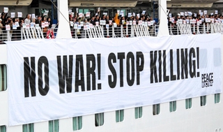 船上のデッキで反戦を訴える乗客ら＝神戸市中央区新港町、神戸ポートターミナル