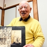 アルバムを手に父寿生さんとの思い出を振り返る重村仁さん。２人が１枚に納まる写真はそう多くない＝灘区福住通