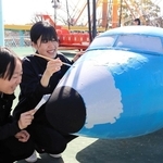 飛行塔の遊具に色を塗る神戸海星女子学院の生徒＝王子動物園