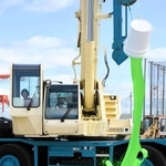 移動式クレーンを使い、操縦役と指示役が協力してペンキをまいていく＝港湾職業能力開発短期大学校神戸校