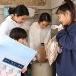 未来の自分に宛てた手紙や写真などをタイムカプセルに入れる児童＝長尾小学校