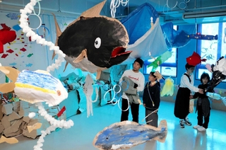 水族館の水槽を見立てた空間に、児童が工作した魚が展示されている＝神戸市中央区小野浜町
