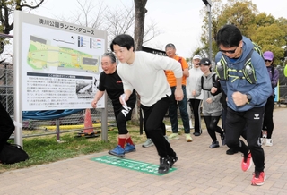 新設された「マラソン発祥の地」の解説板とスタートライン。往時の再現イベントで、参加者が大阪に向けて走り出した＝湊川公園
