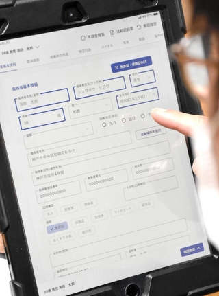救急隊員が傷病者の情報を打ち込むタブレット端末＝神戸市役所