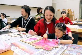 パズルピースの形の段ボールに好きな色を塗る参加者＝県立美術館