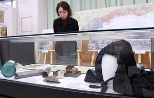 防空頭巾など戦時中の市民生活を伝える展示品が並ぶ＝戦災記念資料室