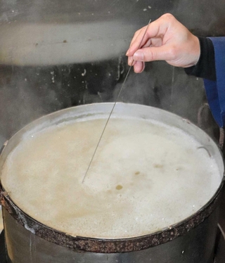 豆の炊き具合をピアノ線で確認する。修業を積んで身に付けた技術だ＝神戸市兵庫区塚本通５