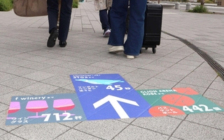 ペンギンが泳ぐスピードやワイングラスの個数で距離を表している案内サイン＝神戸市中央区新港町