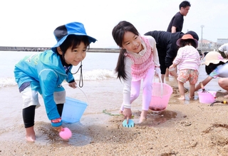 スコップや熊手を手に潮干狩りを楽しむ子どもたち＝須磨海岸