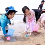 スコップや熊手を手に潮干狩りを楽しむ子どもたち＝須磨海岸