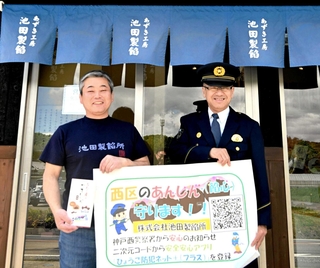県警のアプリのＰＲに協力する池田製餡所の池田直史さん（左）と阿部義樹神戸西署長＝池田製餡所