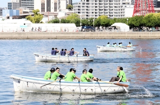勝利を目指して力いっぱいオールをこぐ参加者＝神戸市中央区新港町