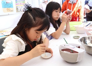 皿にウサギの絵を描く子どもたち＝神戸市住吉公園グラウンド