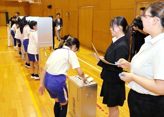 「誰に入れようかな…」。模擬投票で一票を投じる児童ら＝神戸祇園小学校