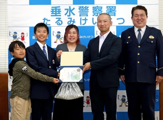 歩道橋から飛び降りようとした女性を引き止めた坂本知仁さん（右から２番目）と家族＝垂水区本多聞３、垂水署