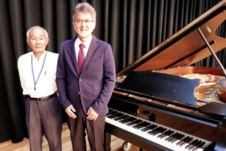 御影公会堂へのスタインウェイの移設を実現した山中昭文さん（右）＝東灘区御影石町４