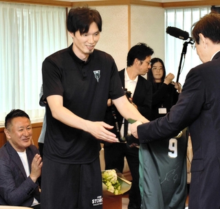 永久欠番となる自身の背番号入りのユニホームを贈る谷直樹選手（左から２人目）＝神戸市役所