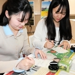 完成したインクで文字を書く学生＝神戸市中央区港島１、神戸学院大学