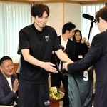 永久欠番となる自身の背番号入りのユニホームを贈る谷直樹選手（左から２人目）＝神戸市役所
